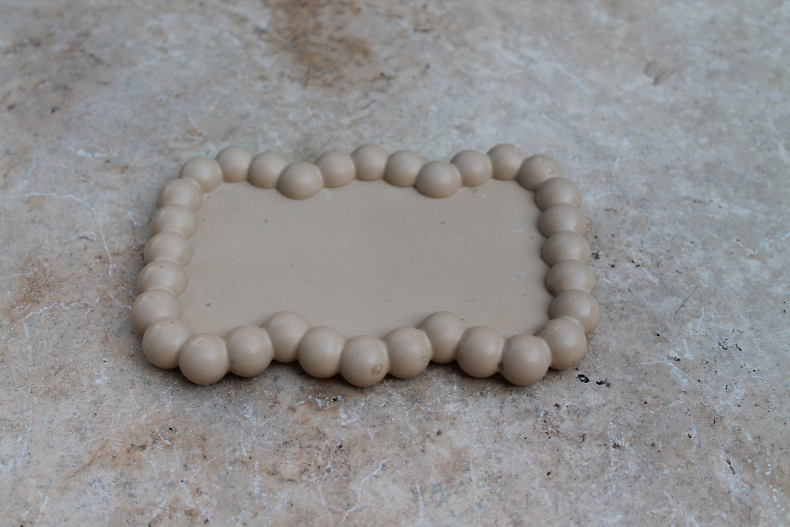 Plateau à rebord beige pierre minérale sur une coiffeuse — Maison Cholo