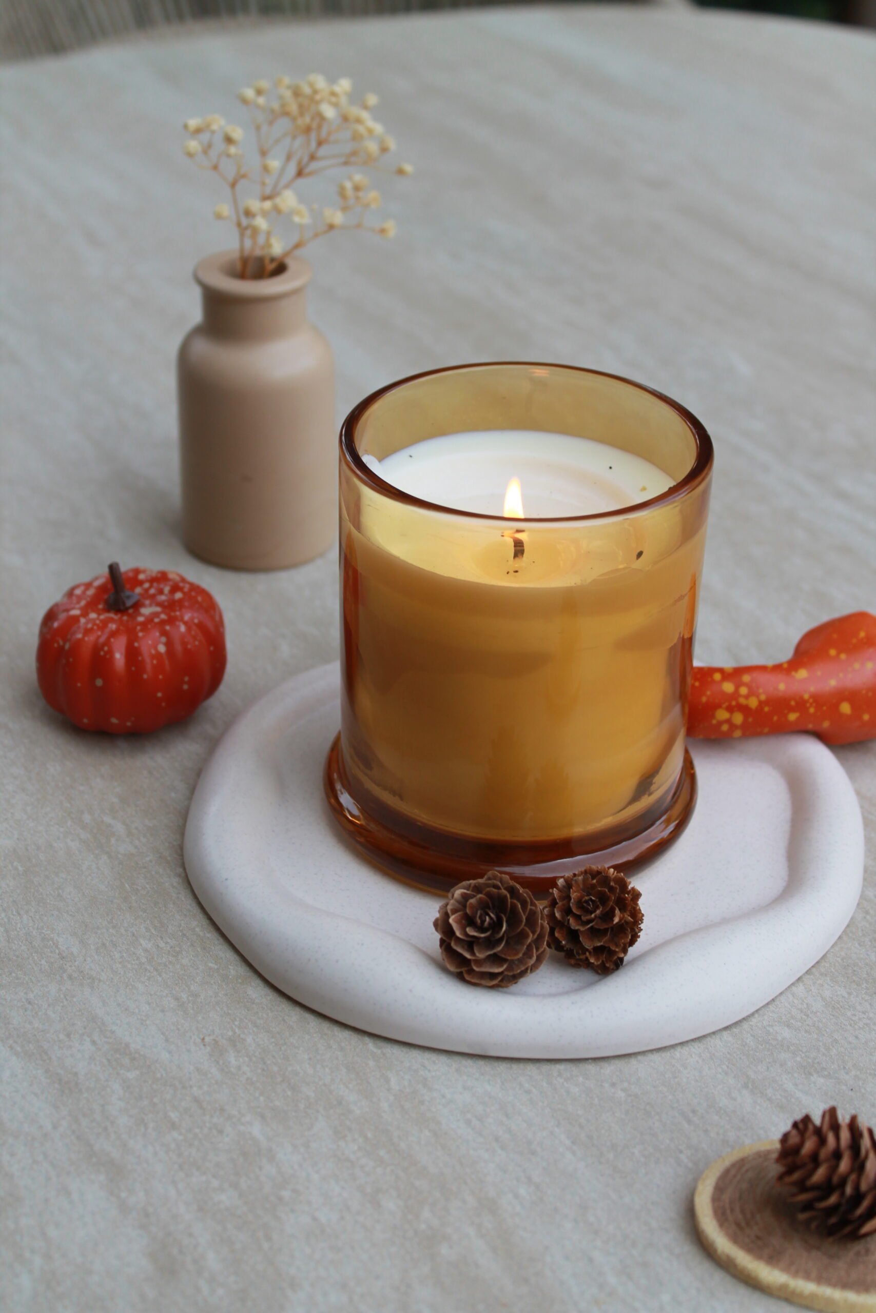 Plateau effet pierre sur table basse avec bougie, mini vase et fleurs séchées