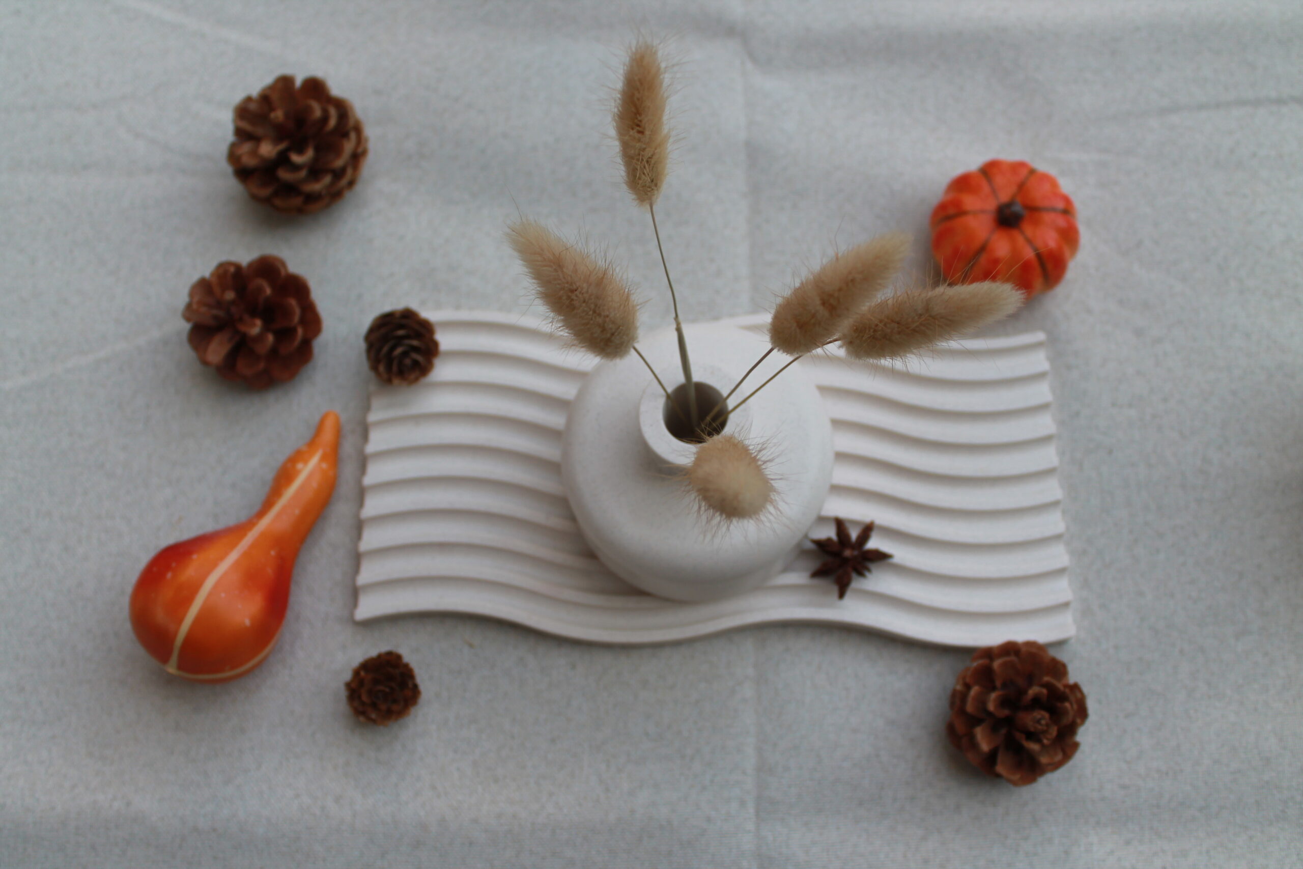 Table d'automne avec plateau ondulé, bougies et mini vases effet pierre